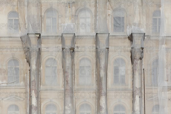 Facade of a historic building shrouded with tarpaulins during renovation