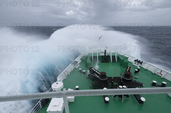 A huge wave is breaking over the bow of the expedition cruise ship MS Expedition in the Drake Passage