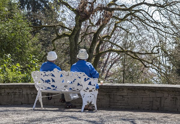 Senior couple sitting on a bench in a park