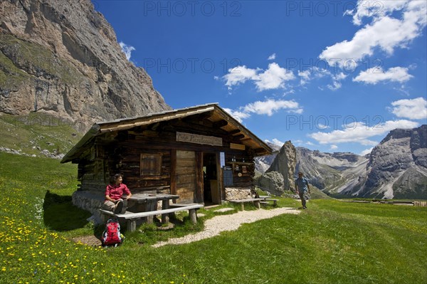 Woman taking a break on the Malga Alm alpine pasture below the Odle Mountains