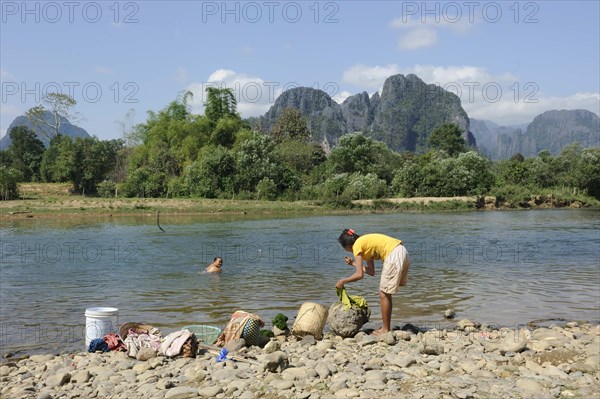 Laotian women washing clothes in the Nam Khan River