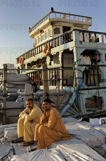 Dockers sitting on sacks on a dhow