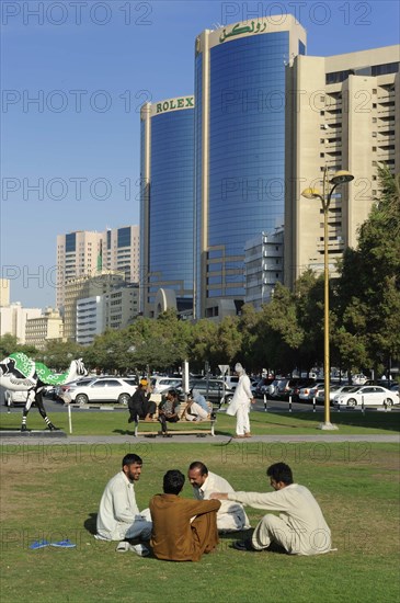 Locals in a park in front of the Rolex Towers