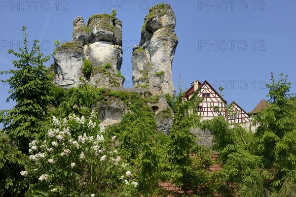 Half-timbered houses next to towering karst rocks