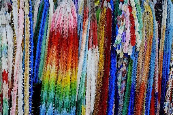 Garlands of folded objects on sale as good luck charms