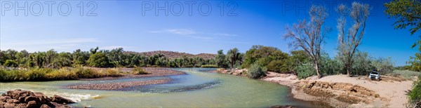 Off-road vehicle parked beside the Kunene River