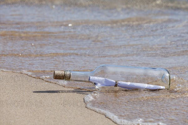 Message in a bottle lying on the beach