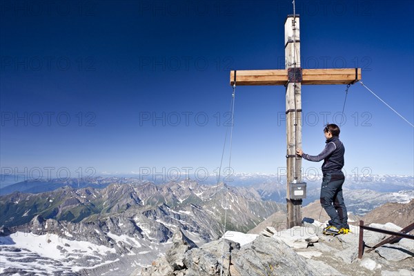Mountain climber at the summit cross of Hochfeiler Mountain