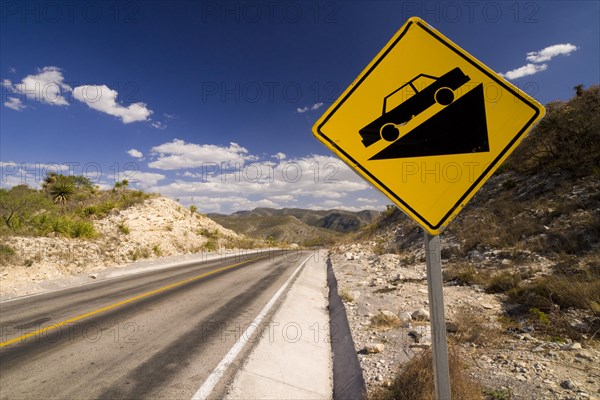 Warning sign on a sloping road