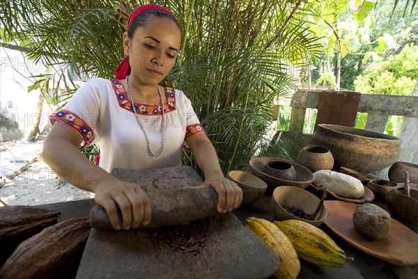 Farm worker grinding cocoa beans at the Hacianda Cacaotera 'Jesus Maria'