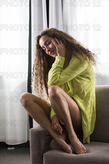 Young woman only wearing green cardigan