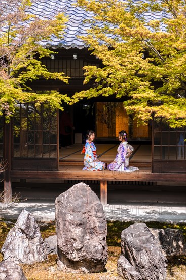 Two Japanese women dressed with kimono sitting in the courtyard of O-shoin