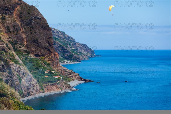 Cliff coast near Calheta with paragliders