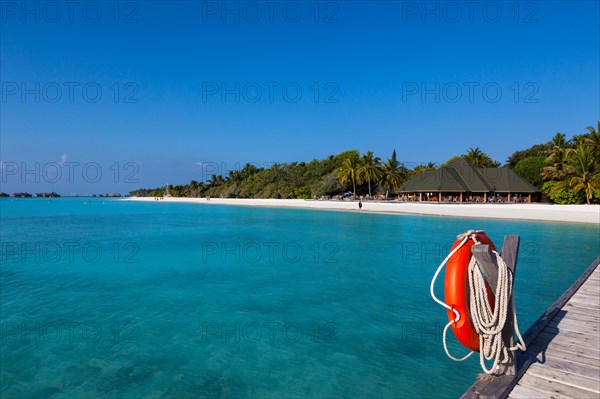 View from a jetty with a life buoy of the beach with a gazebo