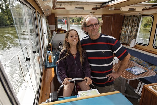 Father and daughter at the wheel of a Penichette