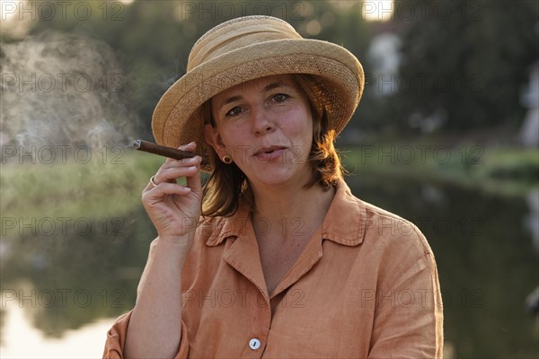 Woman smoking a cigar on a houseboat on the Canal des Vosges