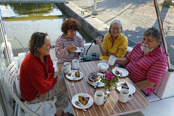 Holidaymakers drinking coffee on the rear terrace of a Penichette