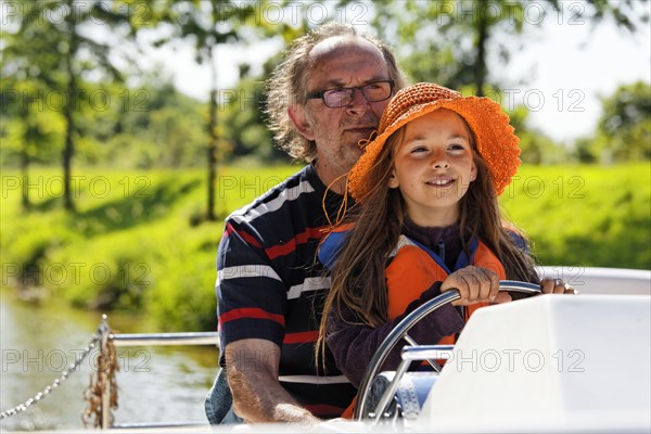 Father and daughter at the wheel of a Penichette