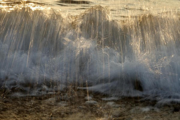 Waves on the beach of Bug on the island Ruegen in the evening sun