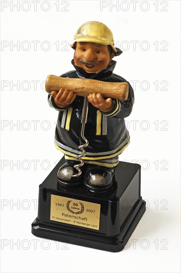 Figure of a firefighter holding a corkscrew in his hands