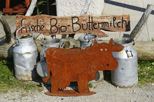 Milk cans in front of the Sonnenalm with a sign 'frische Bio-Buttermilch'