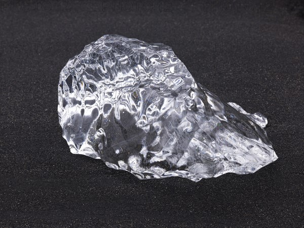 Chunk of ice lying on the black sandy lava beach on the edge of the Vatnajokull Glacier