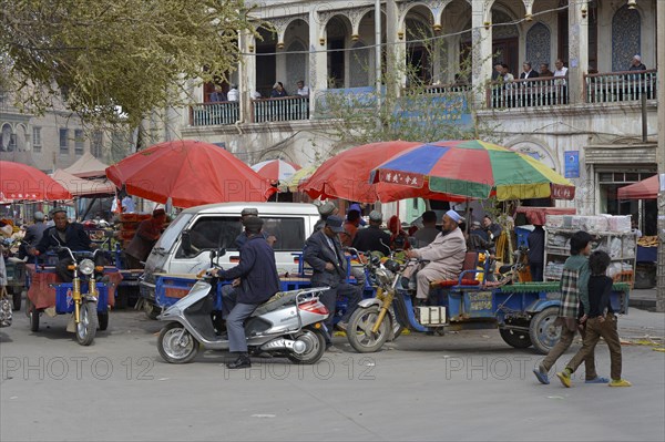 Market stalls with Muslim traders and a tea room on the porch of a mudbrick house