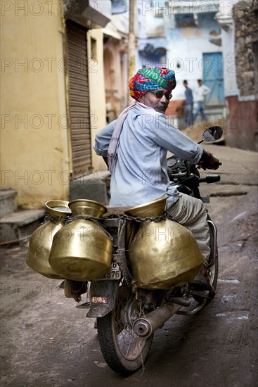 Milkman riding a motorcycle with milk containers