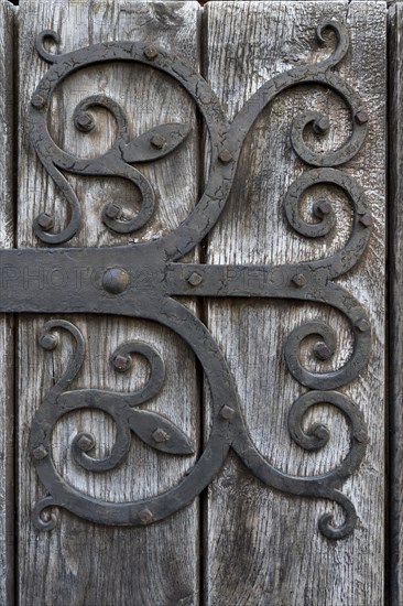 Hand-forged iron works on a wooden door