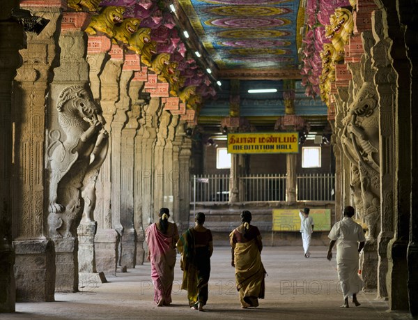 Visitors in the temple hall with brightly painted pillars