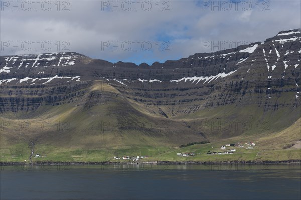 Kunoy village by the sea in front of steep mountains