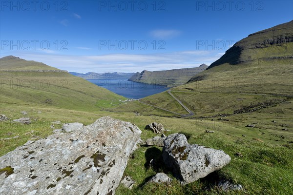View over boulders and the village of Funningur towards Djupini Fjord