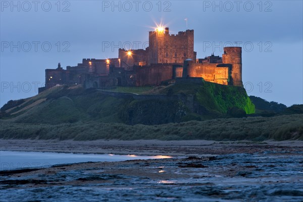 Bamburgh Castle illuminated at dusk