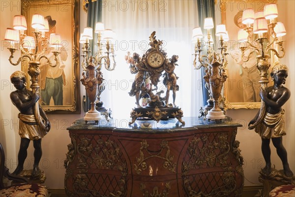 Antique dresser and furnishings adorn a hallway inside a Victorian mansion