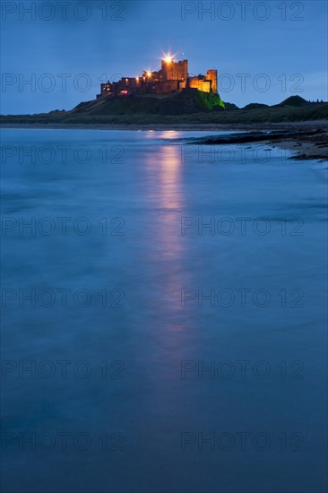 Bamburgh Castle illuminated at dusk