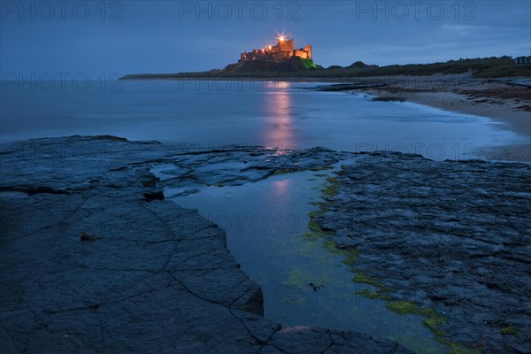 Bamburgh Castle illuminated at dusk