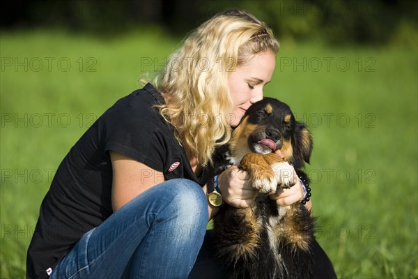 Young woman cuddling an Australian Shepherd dog