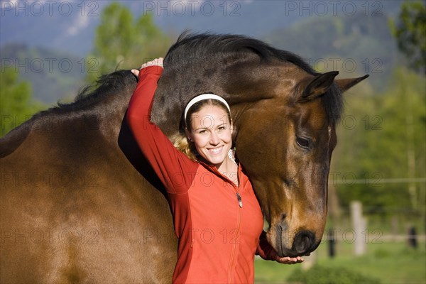 Young woman embracing an Austrian Warmblood