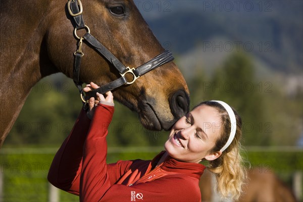 Young woman cuddling an Austrian Warmblood