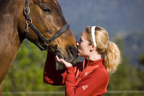 Young woman cuddling an Austrian Warmblood