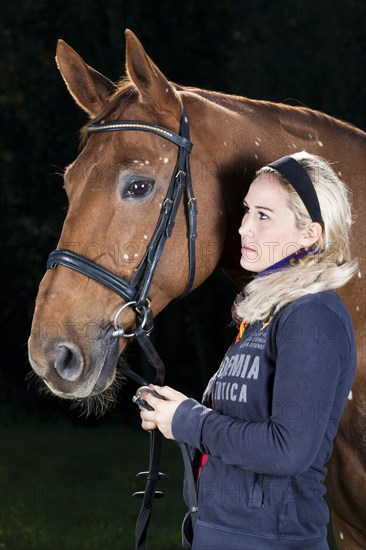 Young woman with a bridled Hanoverian