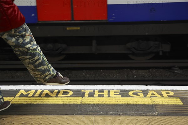 Yellow marking MIND THE GAP on the floor of a station of the London Underground