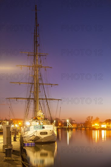 Sailing ship in the fishing port at dusk