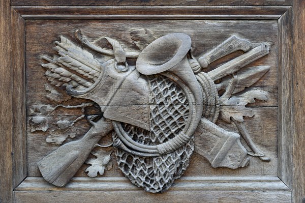 Carved relief image with hunting motifs on the wooden portal