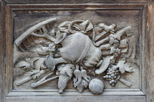 Carved relief image with agricultural motifs on the wooden portal