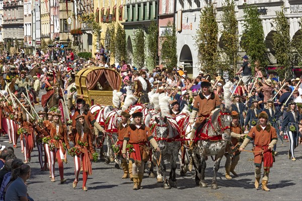 Horse-drawn golden bridal carriage and escorts