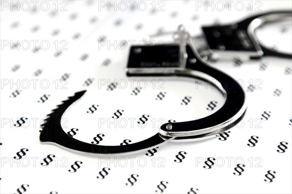 Handcuffs lying on German legal symbols