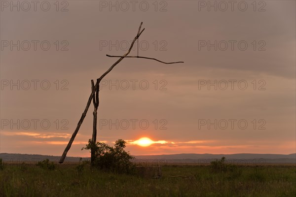 Old drawing well or sweep well at sunset