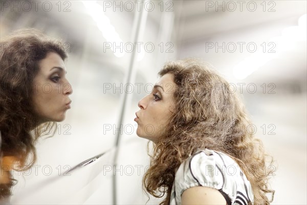 Woman kissing her mirror image