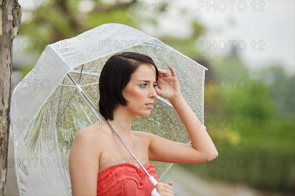 Woman with umbrella outside in a summer rain